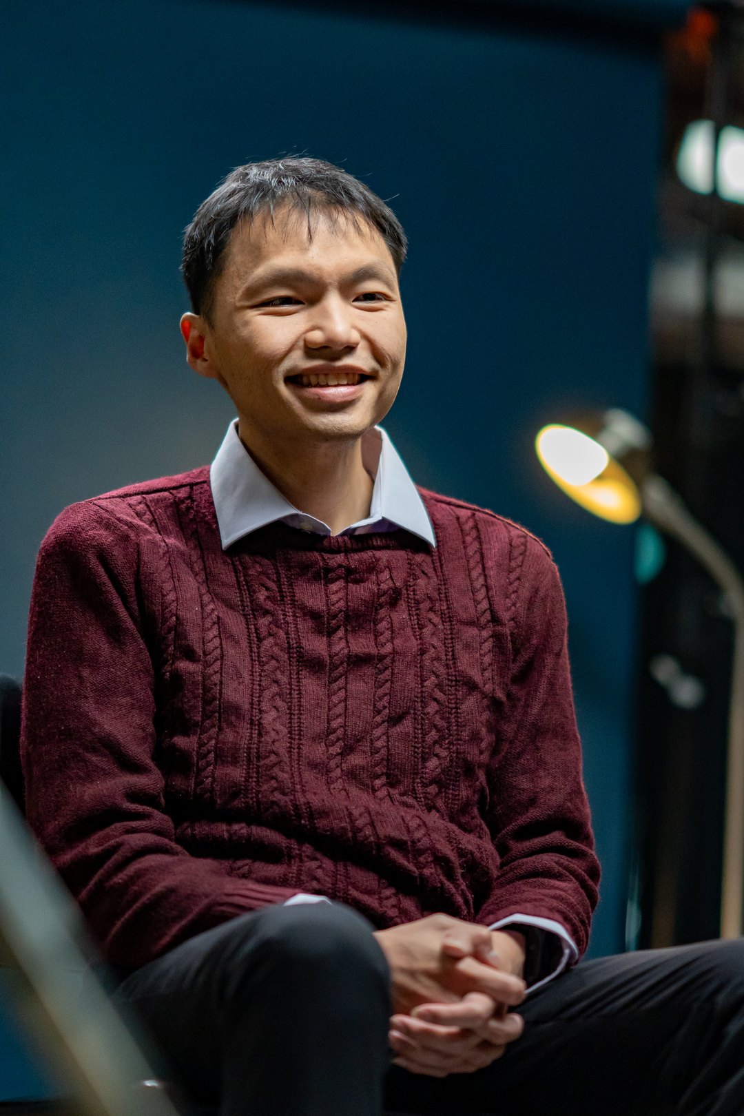 Dr Eric Hadinata seated and smiling in a professional portrait